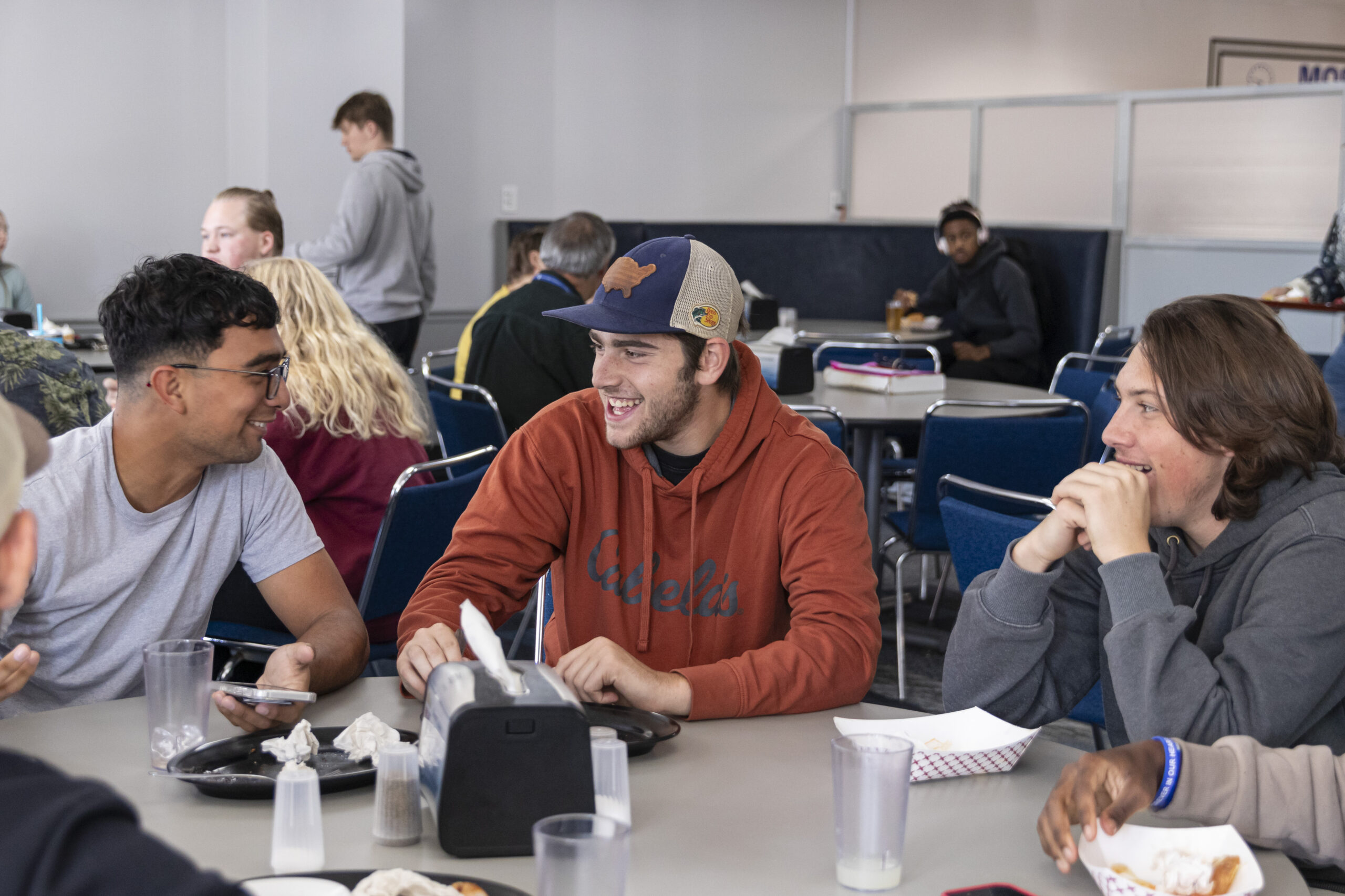 First-year students at Great Lakes Christian College sharing lunch and laughter in the dining hall as they adjust to college life.
